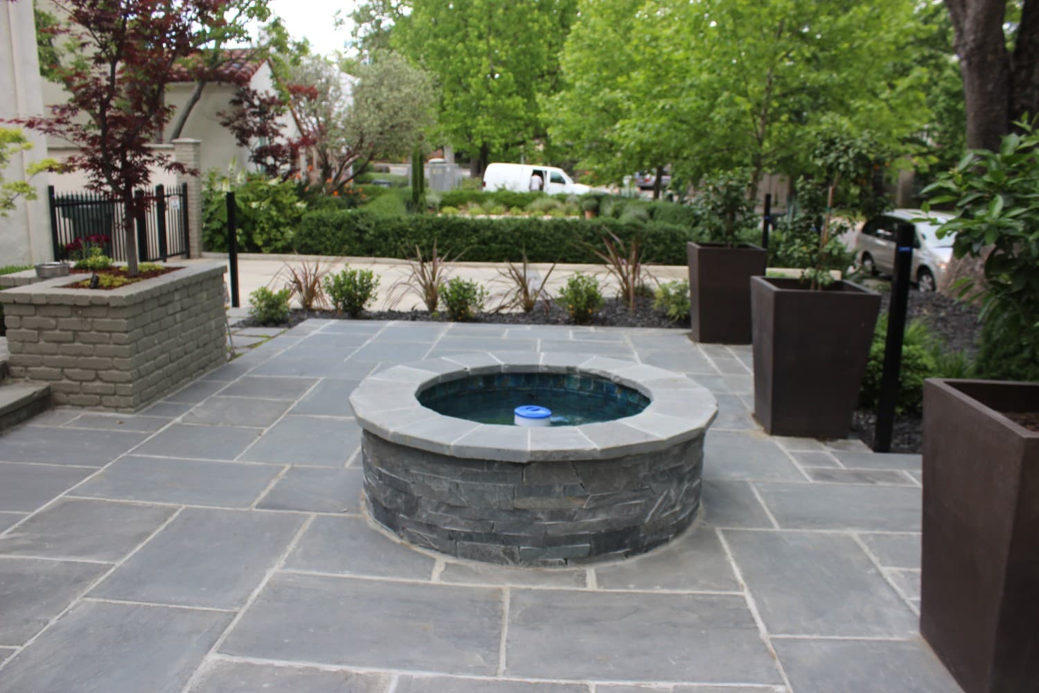 Custom stone-clad spa framed by a bluestone paver patio built by Holt Landscape in Folsom, CA