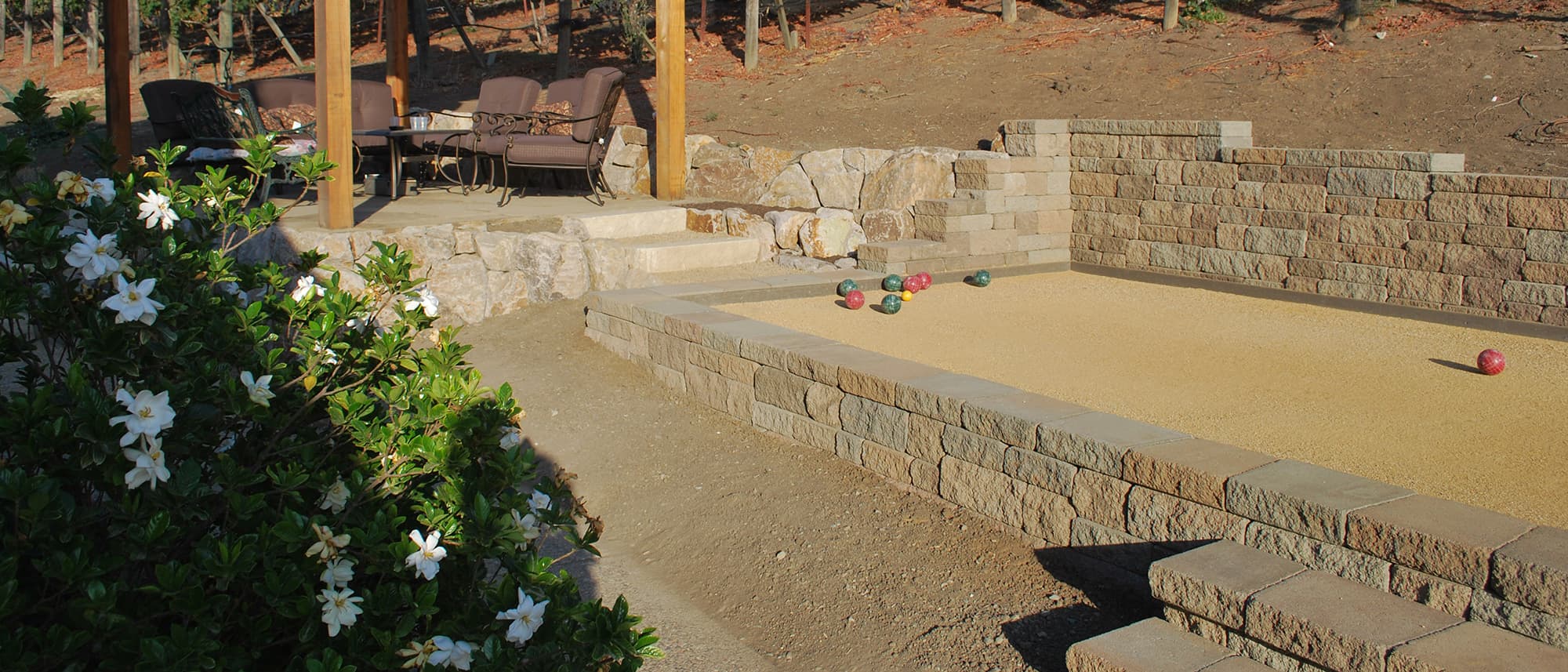 Bocce ball court framed by stacked stone retaining walls installed by Holt Landscape near Rocklin, CA