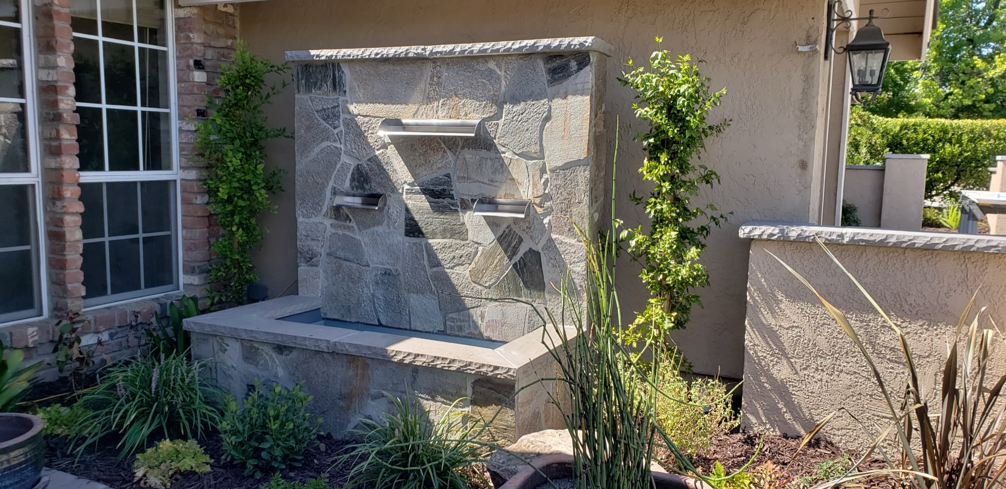 Stacked-stone water wall beside a courtyard entry installed by Holt Landscape near Rocklin, CA