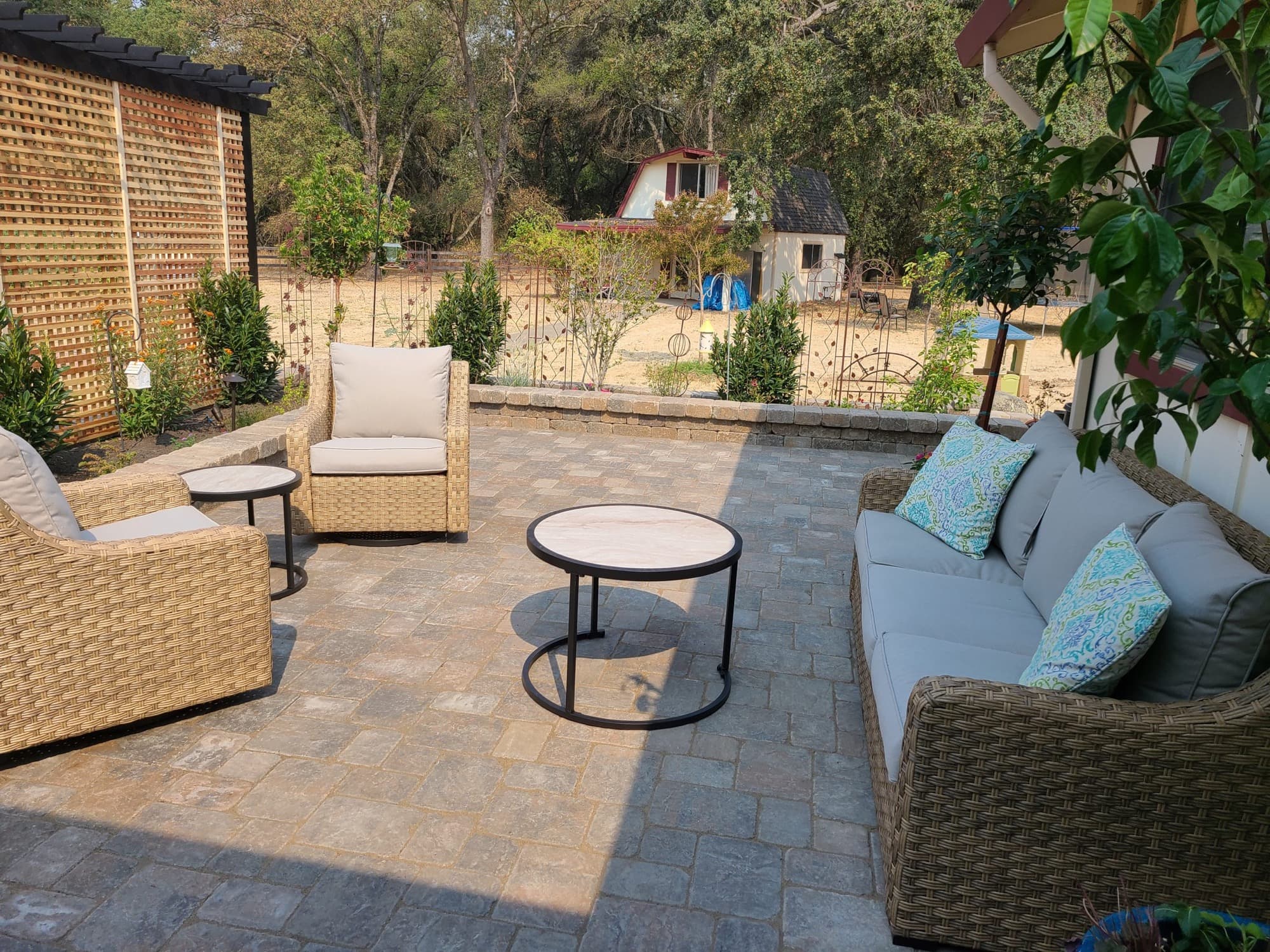Paver patio lounge framed by a wood lattice privacy screen built by Holt Landscape in Folsom, CA