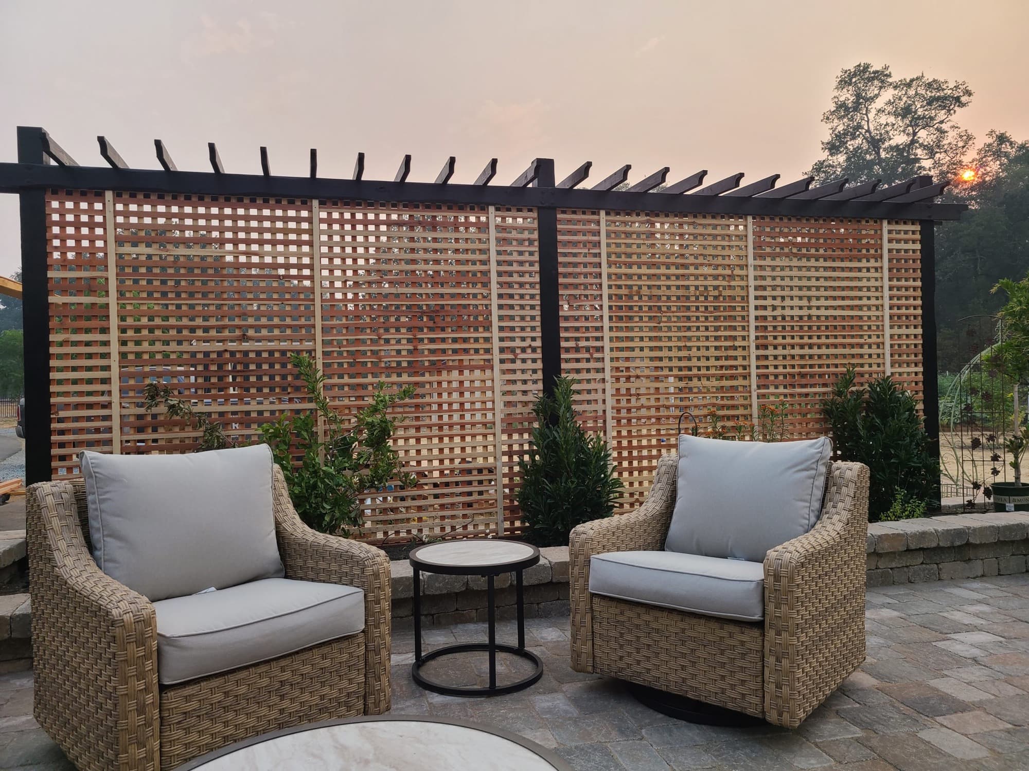 Lattice-roof pergola shading a paver patio lounge at sunset built by Holt Landscape in Lincoln, CA