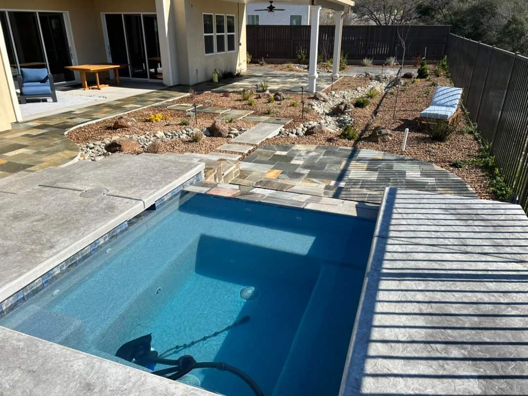 Pool and raised spa with multi-level bluestone patio decking installed by Holt Landscape near Roseville, CA