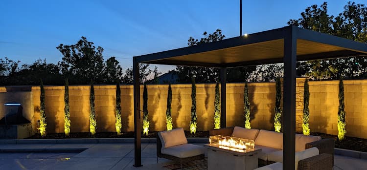 Fire pit table glowing beneath a modern patio cover at dusk in Loomis, CA